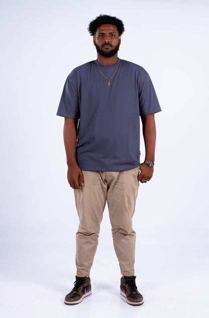 A person wearing a medium gray oversized t-shirt, front view